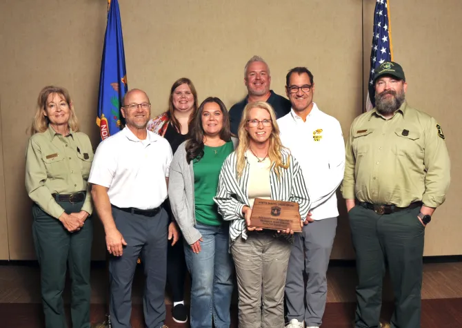 A group of people holding a plaque and smiling