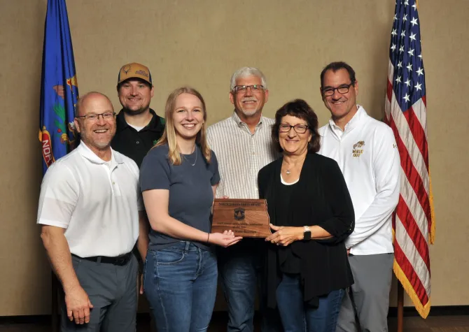 A group of people holding a plaque and smiling