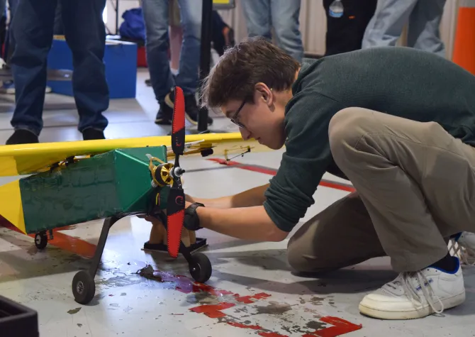 electronic engineering student working on a small airplane