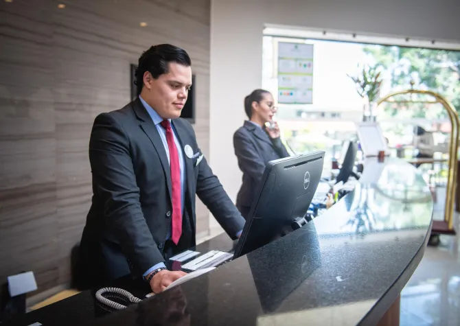 Hotel front desk clerk looking at computer screen