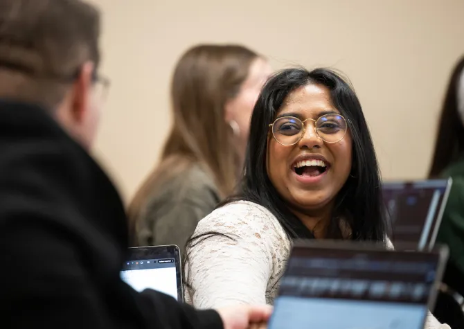 Student laughing while looking at a classmate. 