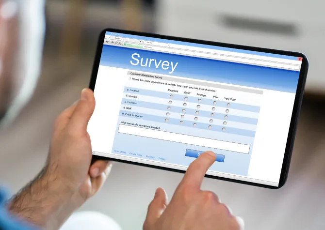 image of man holding tablet with survey on it