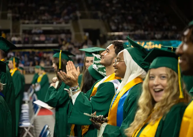 graduates standing together during commencement ceremony