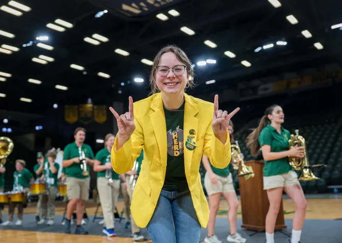 yell leader gives Bison horns to the camera during Discover NDSU
