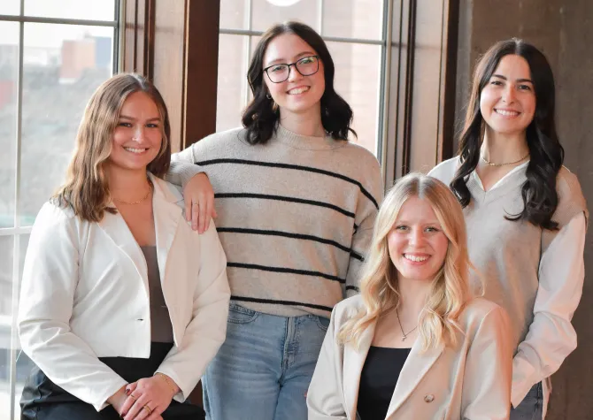 Four women smiling confidently at camera.