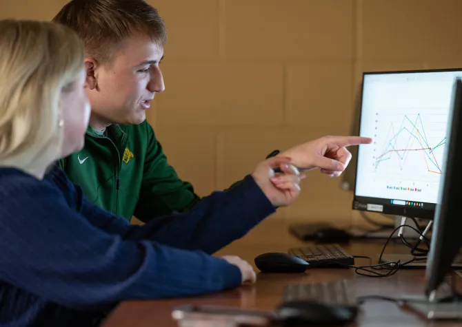 students examine graphs and charts during a Business class