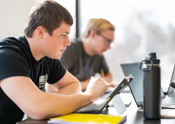 students work on computers and ipads in class