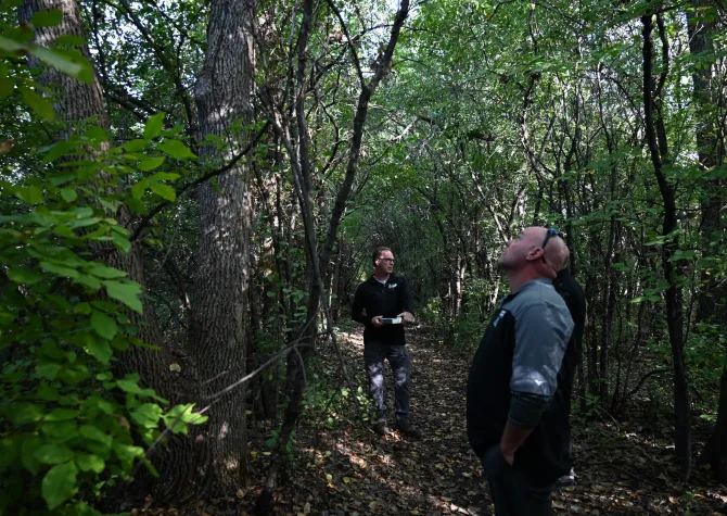 A man giving a presentation in the woods.