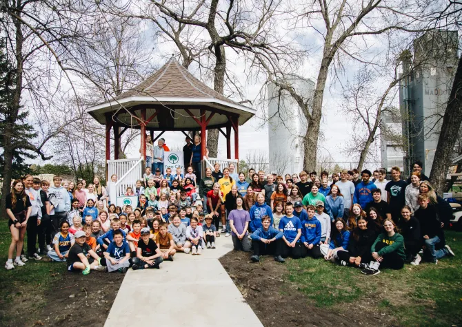 Students and community members pose for a photo outside the newly refurbished gazebo in Maddock on their Arbor Day.