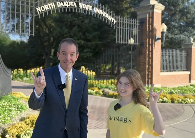 man and woman in front of ndsu gates