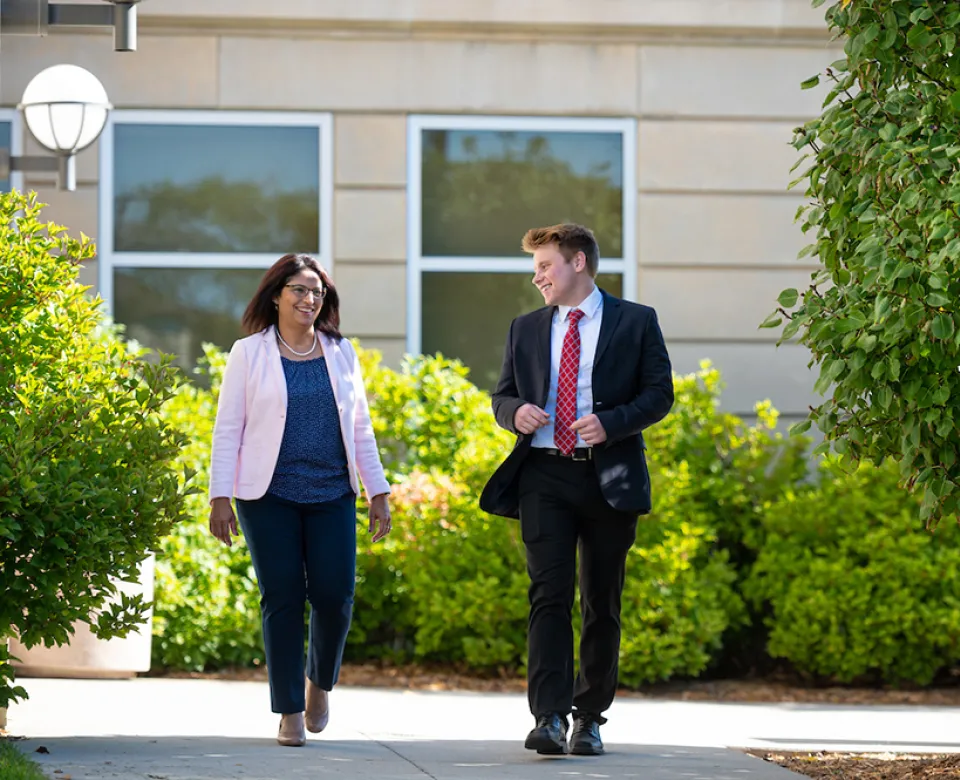 Business instructor and student walking outside Barry Hall.