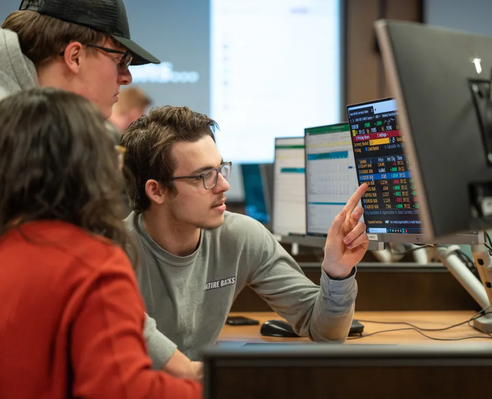 Students sitting at computer in commodity trading room.