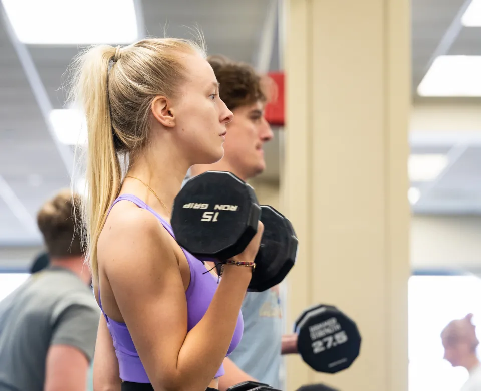 Female student lifting dumbbells
