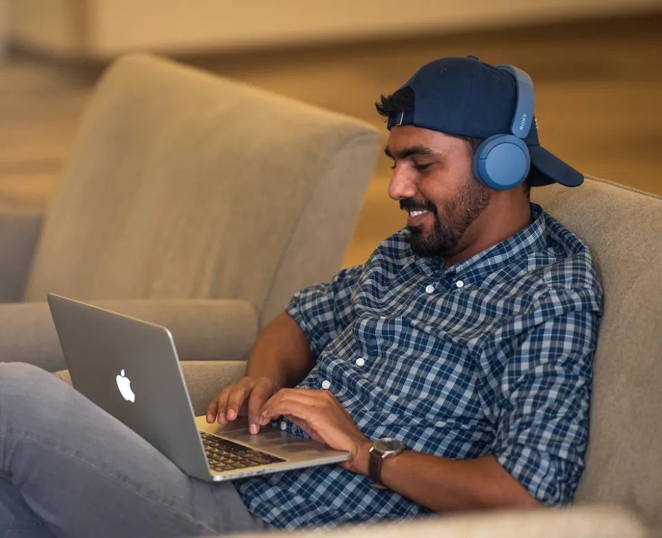 student working on laptop wearing headphones