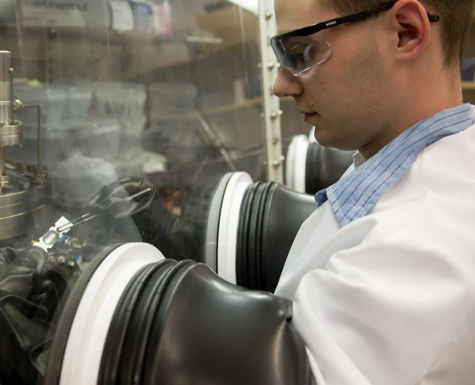 A researcher uses a device that encloses his hands in rubber gloves