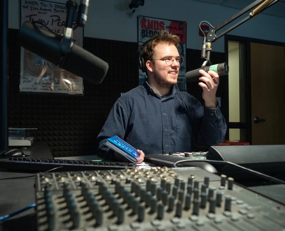 student running a podcast and working in the sound studio
