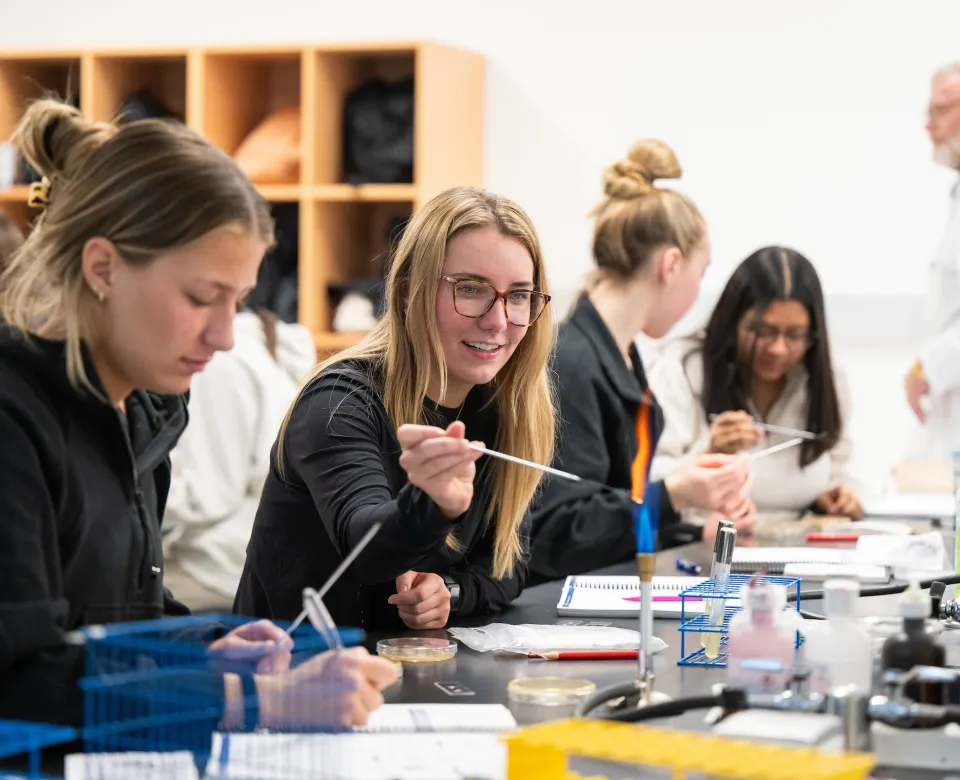 Student working with a bunsen burner in a lab. 