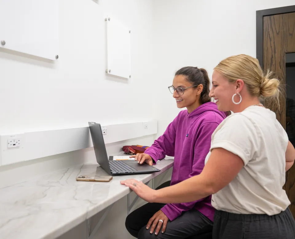 Students looking at laptop in lab