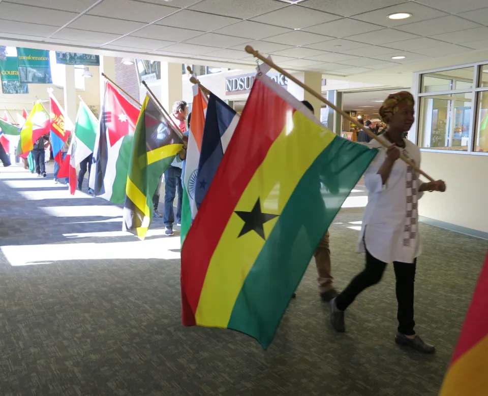 A line of students holding various national flags