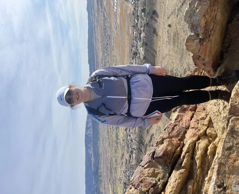 Sage wearing hiking gear smiling confidently at camera. 