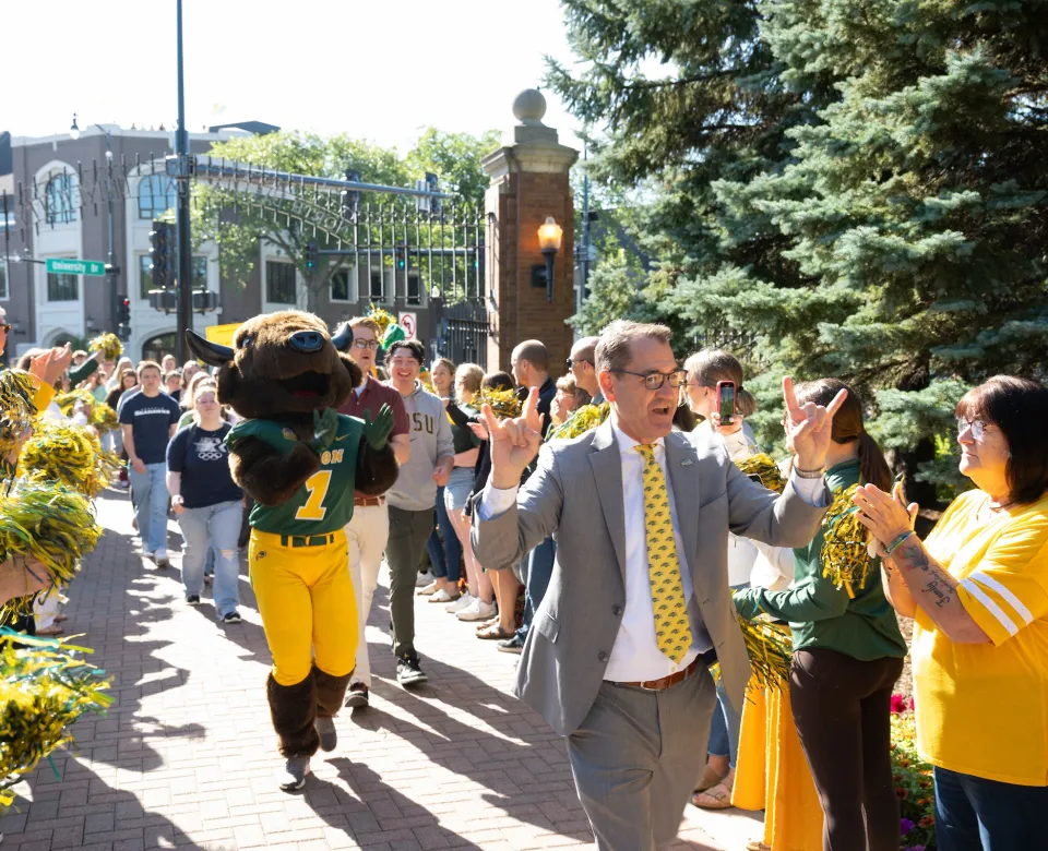 NDSU President David Cook walks incoming students through the university gates.