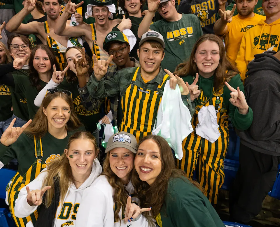 students cheer and give Bison horns during a football game at the Fargodome