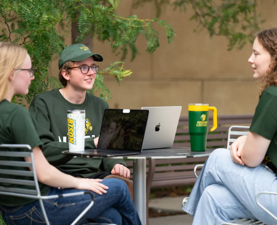 students studying at an outdoor table outside of the Memorial Union
