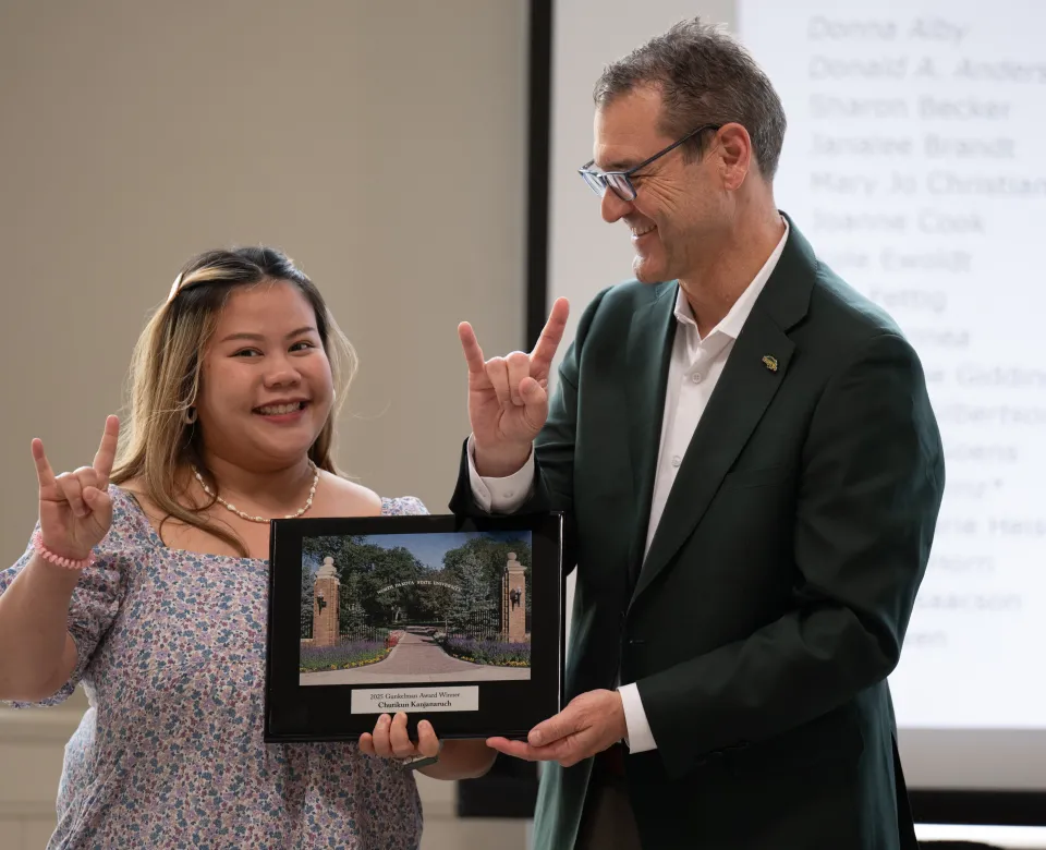 Graduate student with President Cook receiving award