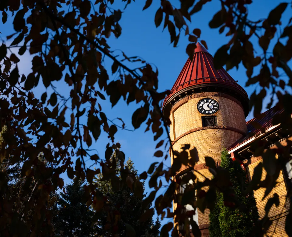 Old Main clock tower showing through the fall leaves