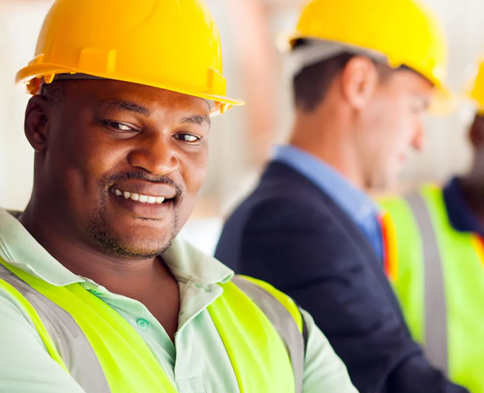 Three men with hard hats working on construction site