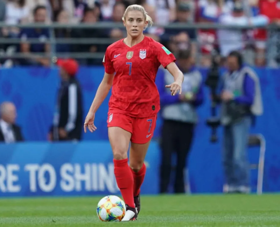 woman soccer player looking off camera ready to kick a soccer ball