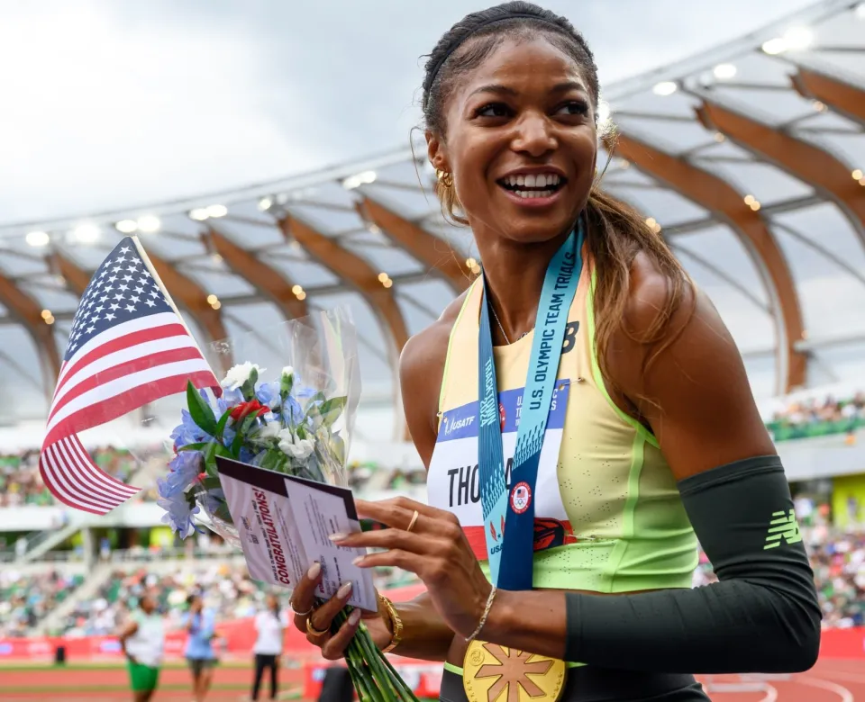 Gabby Thomas with flag and medal