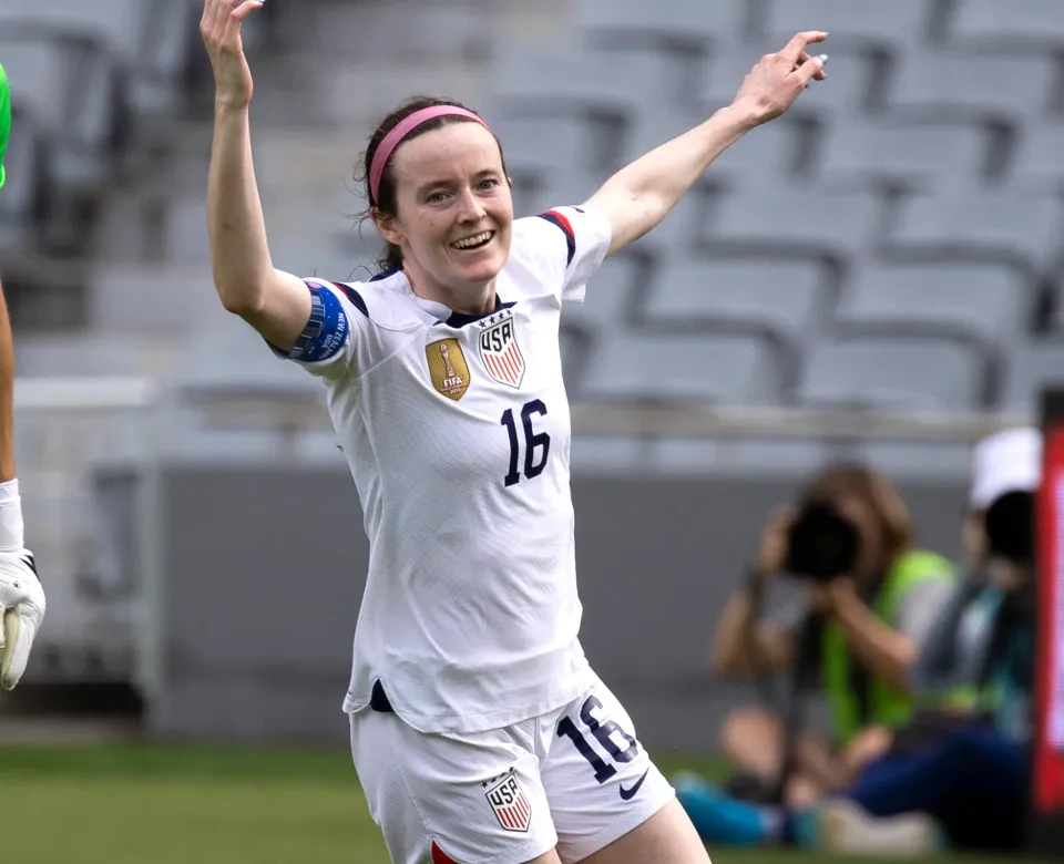 woman soccer player with arms out smiling