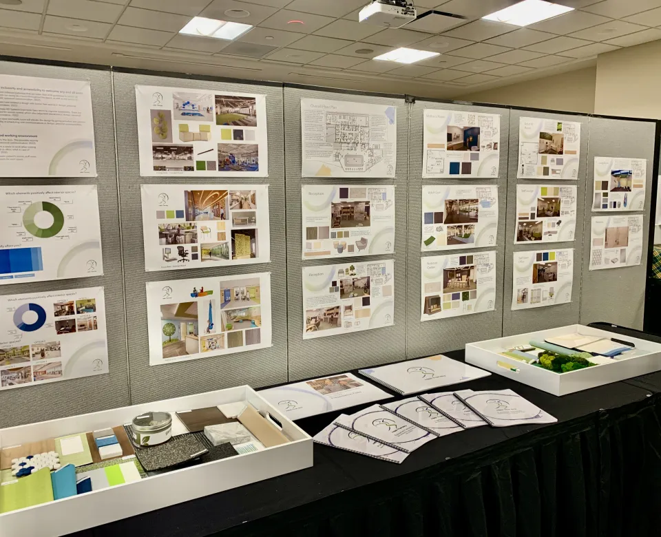 Table display of interior design projects and posters.