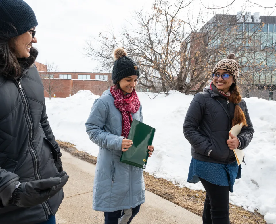 three students walking to class in the winter