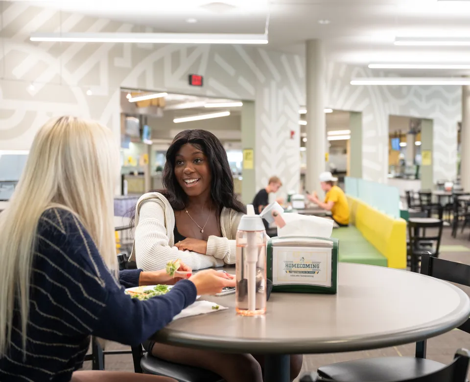 students laughing while they eat together at the West Dining Center