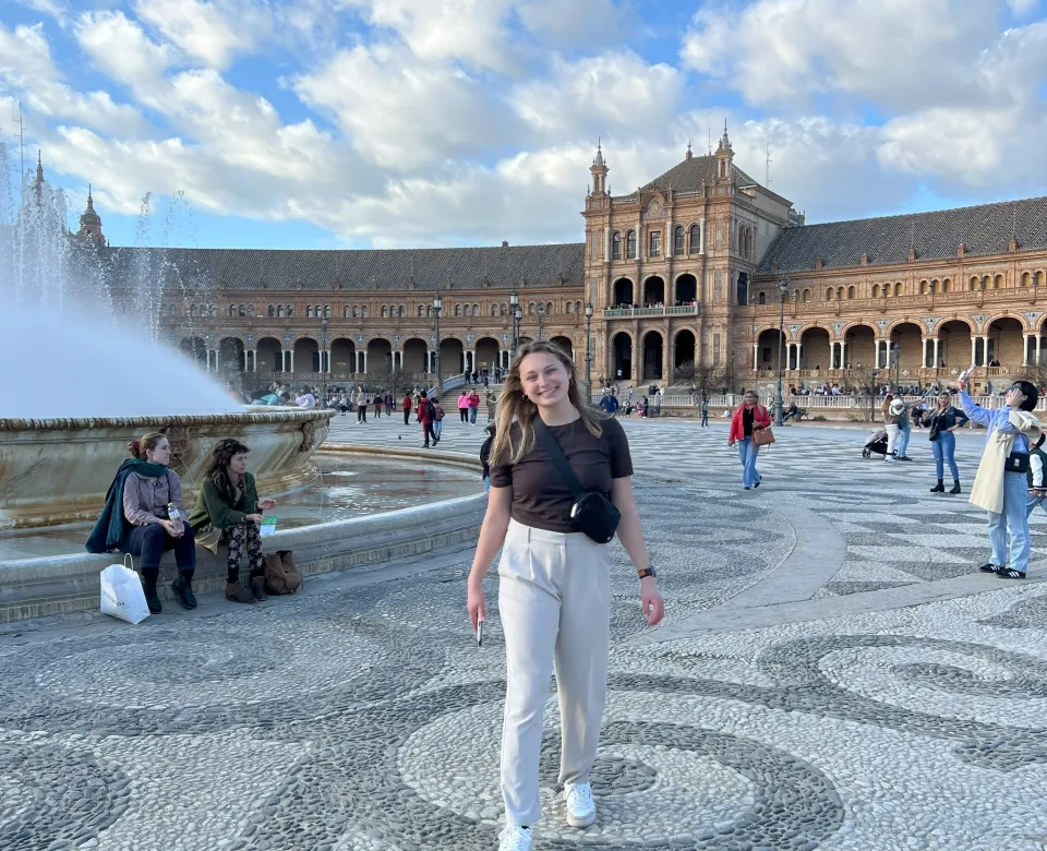 Student in Seville city plaza, right from a fountain