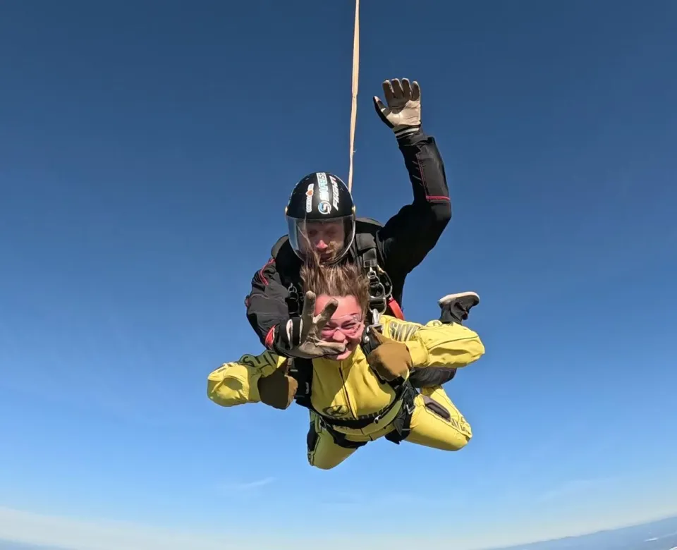 Student skydiving with instructor attached to their back