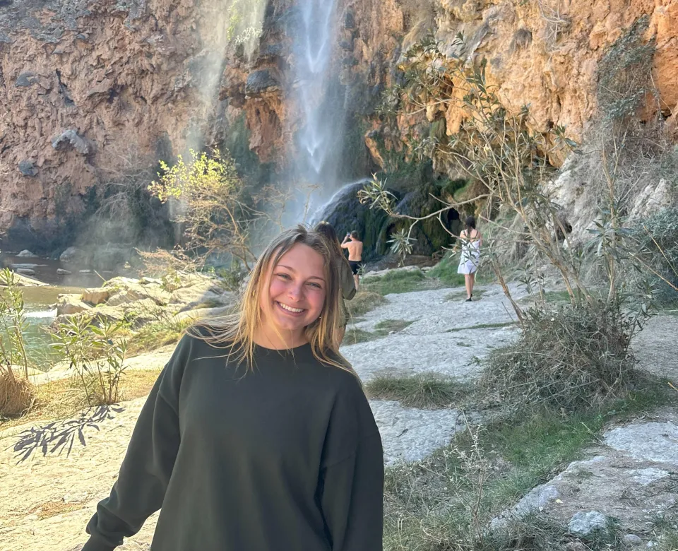 Student in front of waterfall