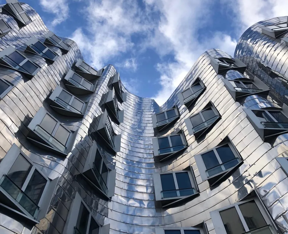 Action shot of large silver building from the bottom up