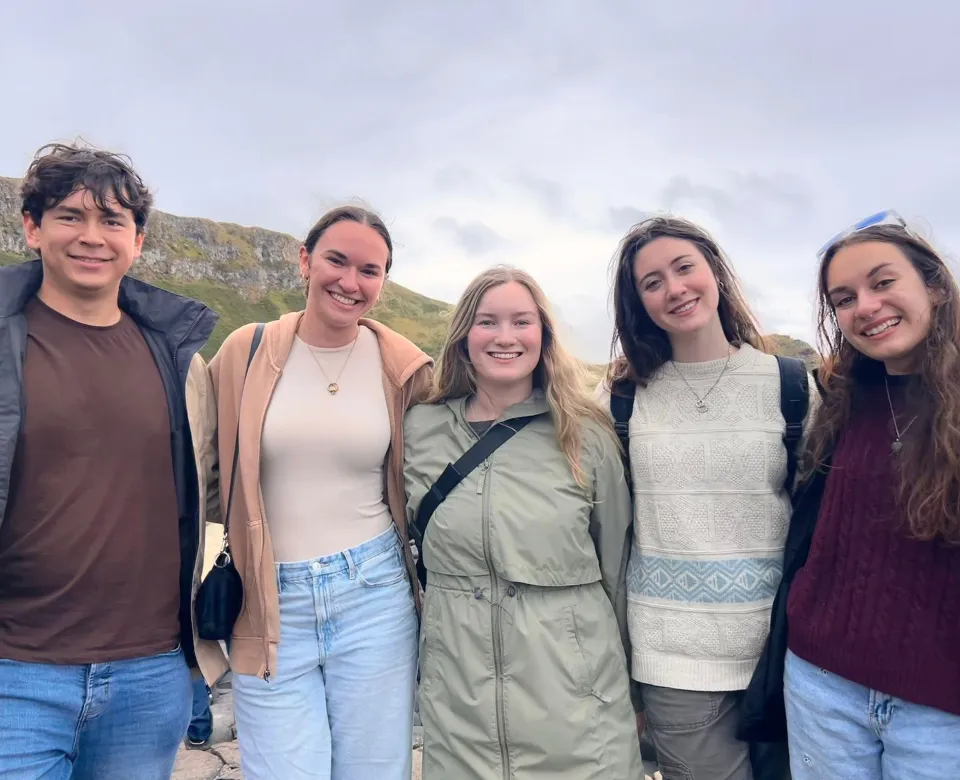 group of five students in front of the giants causeway