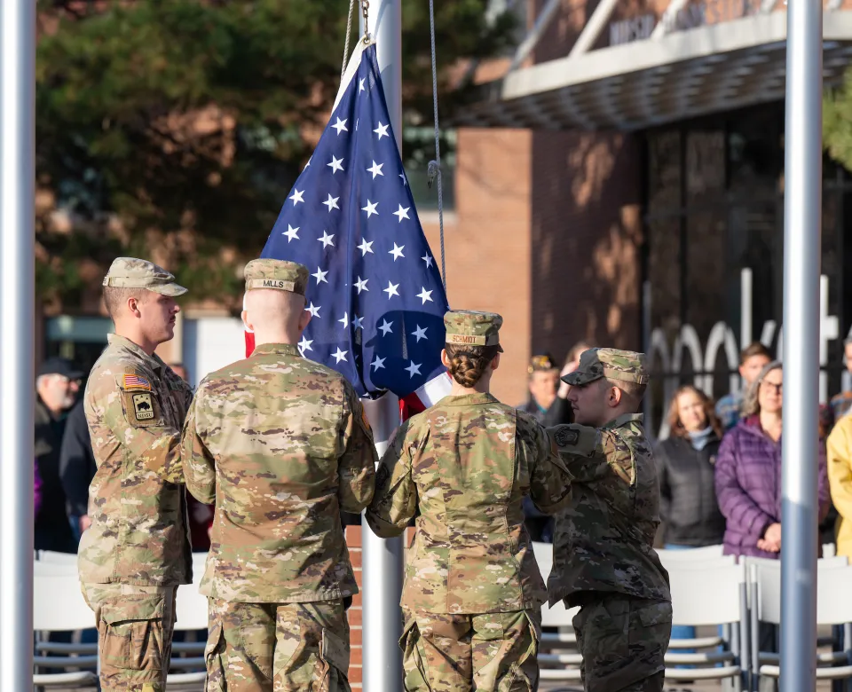 campus military student raise the United States flag in from of the Memorial Union