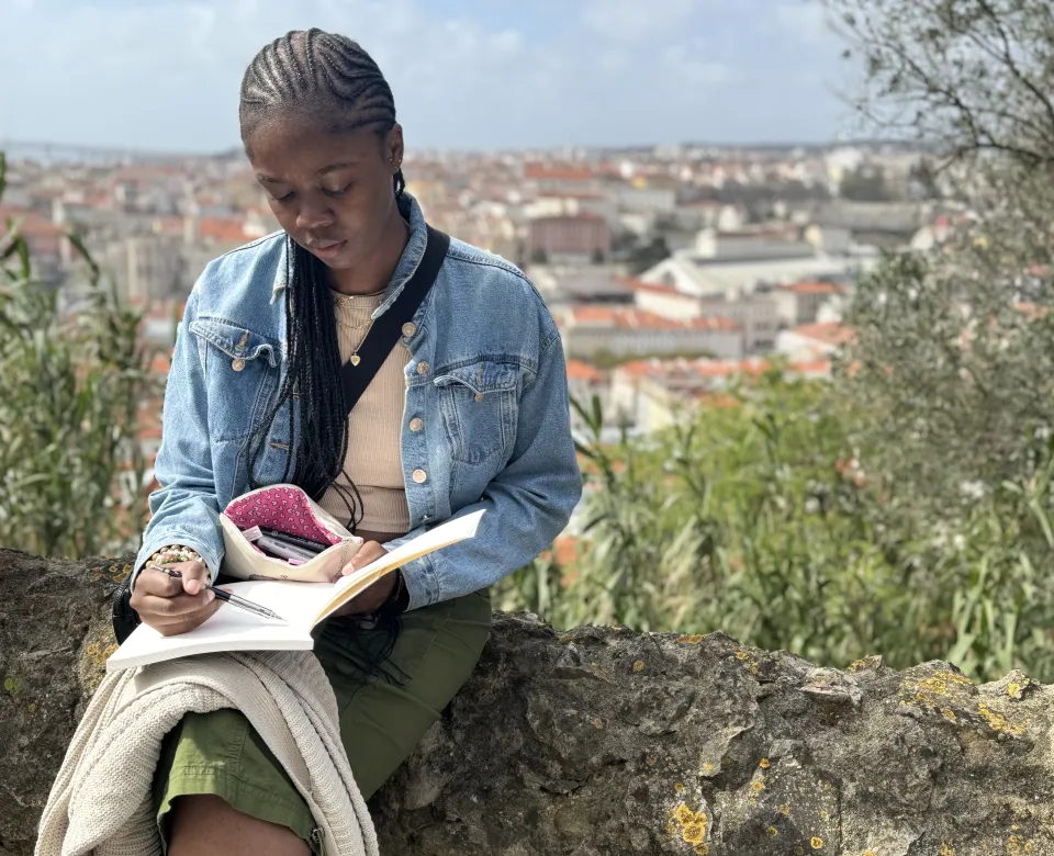 Student studying on top of stone ledge 