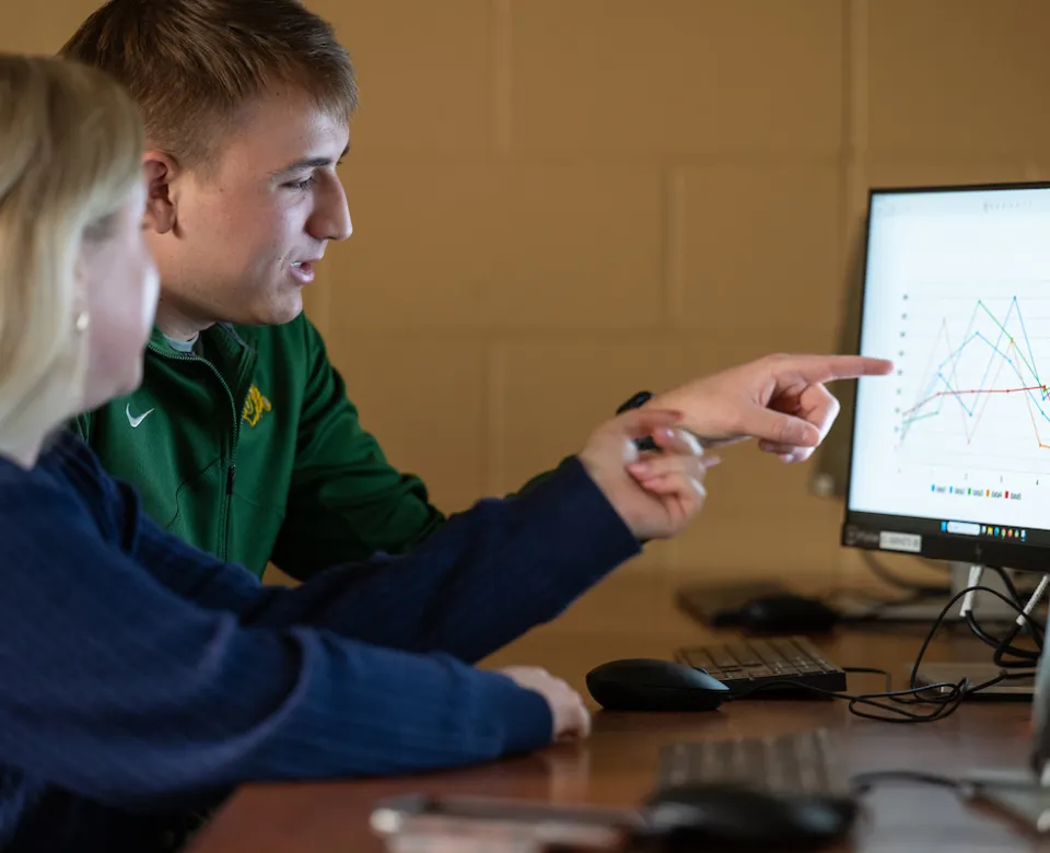 students examine graphs and charts during a Business class