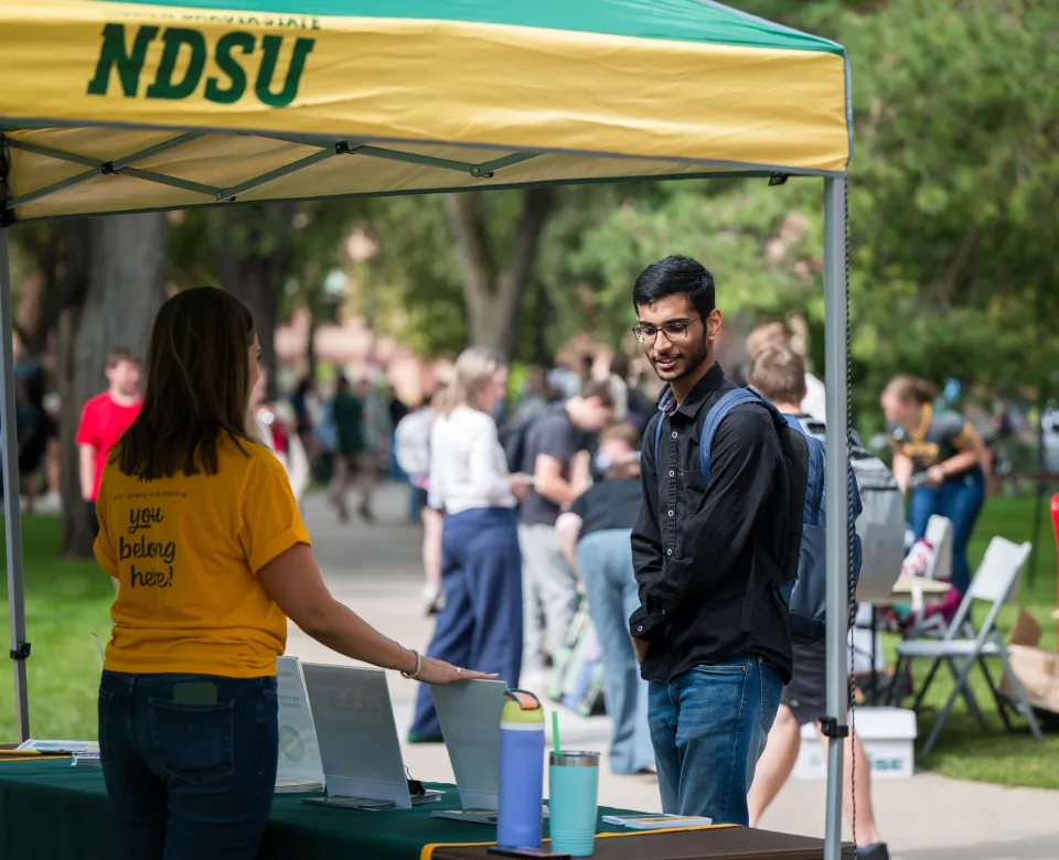 A student talks with an NDSU employee at a student involvement event