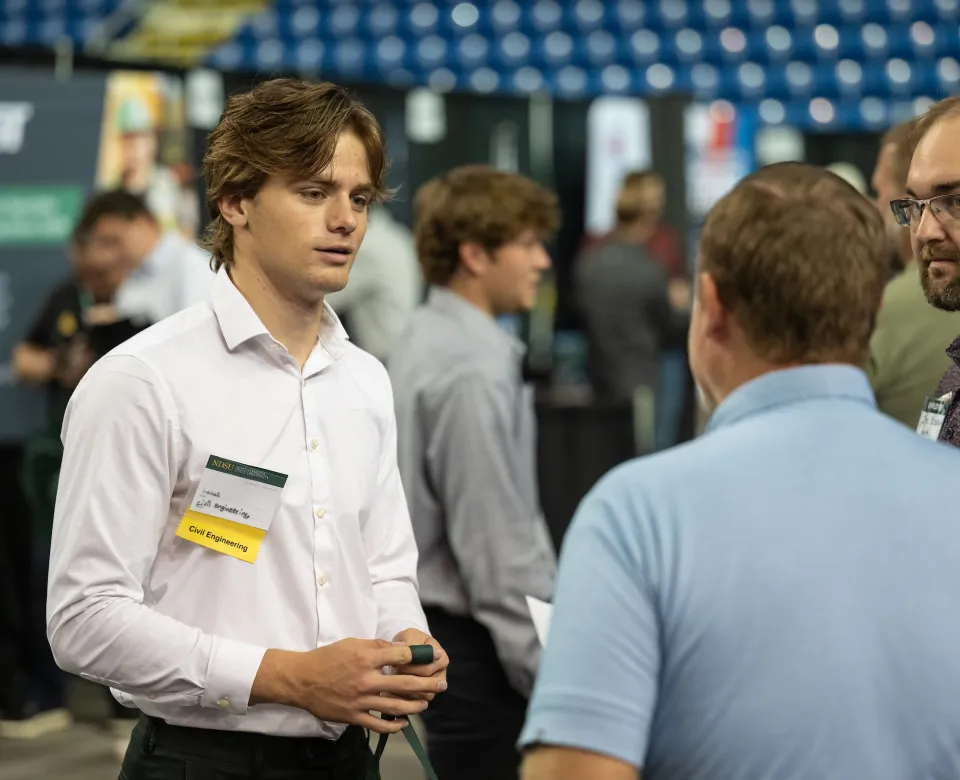 NDSU student chats with potential employers during a career fair