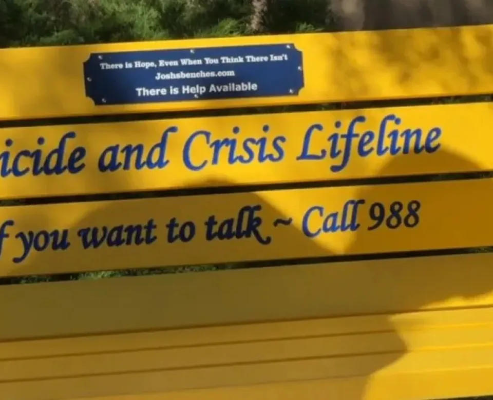 Yellow bench honoring the Suicide and Crisis Lifeline with Call 988 contact information