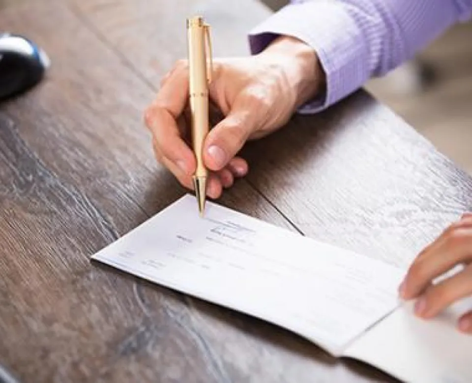 Person with a pen reviewing and signing up for employee benefits