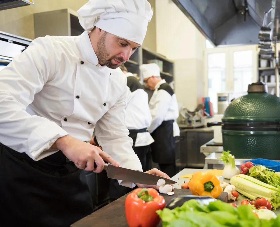 Chef cutting vegetables in a kitchen