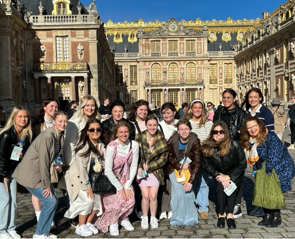 Students posing in front of a large ornate building while studying abroad.